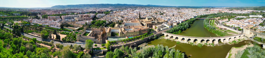 Cordoba, Andalusia. Aerial view of city medieval buildings and bridge on a sunny spring day - obrazy, fototapety, plakaty