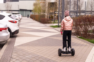 Young girl riding electric mini segway hover board scooter. ecological urban transportation technology. Electric self-balancing scooter board