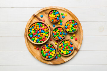 different colored round candy in bowl and jars. Top view of large variety sweets and candies with copy space