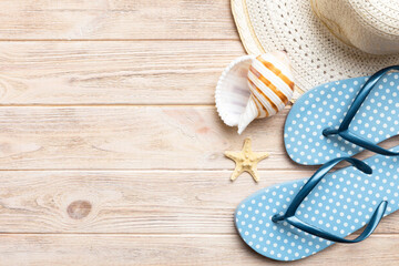 Summer travel concept. Flip flops, summer hat and starfish on white. Top view on colored background