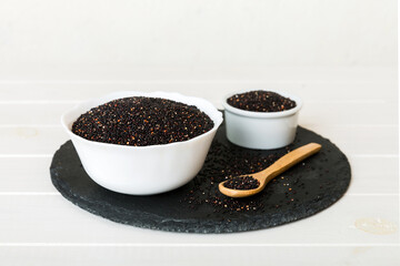 quinoa seeds in bowl and spoon on colored background. Healthy kinwa in small bowl. Healthy superfood