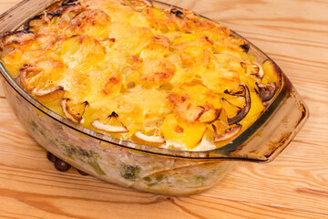 Baked vegetable and fish gratin in the glass baking dish