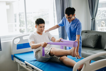 Fototapeta premium Physiotherapist Helping Patient While Stretching His Leg in bed