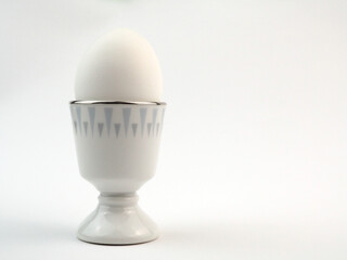 Boiled white egg in a stand, isolated on white background