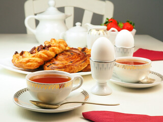 Breakfast with egg, tee, milk, buns, strawberry