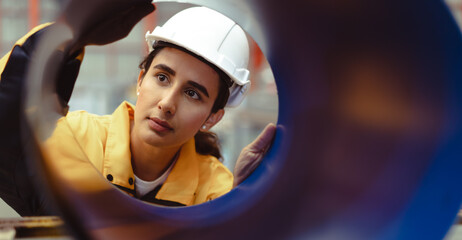 Latin engineer wears safety helmet work in heavy metal engineering factory. Young female hispanic...