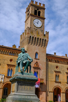 Monument of Giuseppe Verdi closeup on the square of Giuseppe Verdi across the building of theater in Busseto, Italy