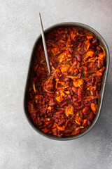 Healthy breakfasts and lunches, stewed red beans with carrots, onions and tomatoes, top view of an oval ceramic roaster with stewed legumes