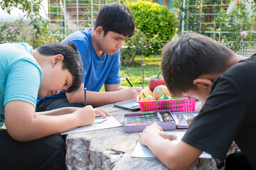Three boys are spending their free times with drawing, sketching, coloring by using watercolor in...