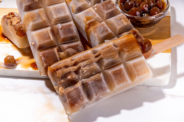 Tapioka latte popsicles. Frozen tapioca boba balls coffee frappe, ice cream lollypops made with asian cold tapioca coffee, with coconut cream and caramel sauce