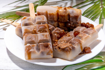 Tapioka latte popsicles. Frozen tapioca boba balls coffee frappe, ice cream lollypops made with asian cold tapioca coffee, with coconut cream and caramel sauce