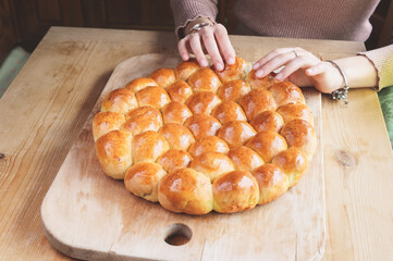 woman hands tearing off a piece of  danube savoury cake