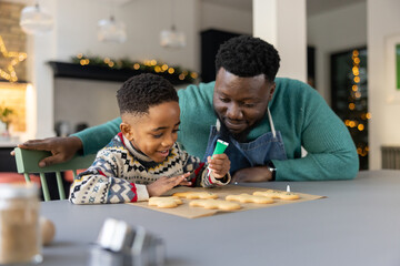 Father and Son decorating gingerbread men together at Christmas