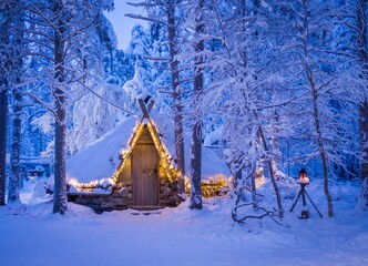 Fototapeta premium Log cabin with lights in the snow arctic circle. Lapland, Finland