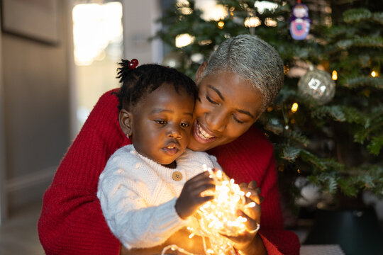 Mother and daughter looking at fairy lights together in preparation of Christmas