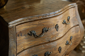 Vintage curved chest of drawers close-up. Forged handles