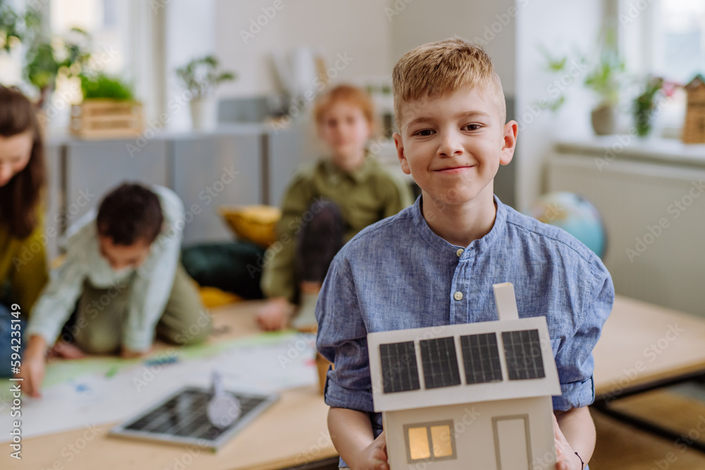 Sticker little boy posing with model of house with solar system during a school lesson.