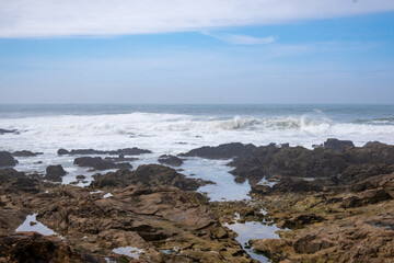 El océano Atlántico revuelto rompiendo las olas entre las rocas de la ciudad de Oporto en un día de primavera.