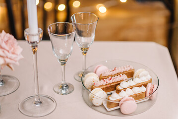 Candlelight dinner setup table. Table setting for couple on Valentine's day in restaurant. Luxury romantic date. Location for surprise marriage proposal. Glasses for wine or champagne and sweets.