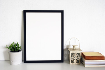 blank frame picture with plants on table in room