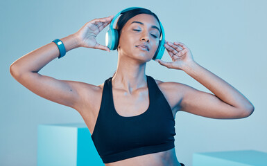 Headphones, fitness and woman isolated on blue background for workout, training or exercise music....