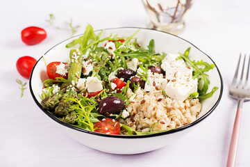 Breakfast oatmeal porridge with feta cheese, cherry tomatoes, asparagus and arugula. Healthy balanced food.