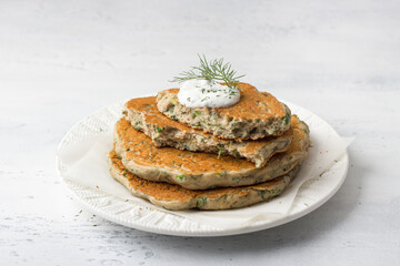 Homemade yeast-free gluten-free  buckwheat flat bread with sour cream, dill and spices on light blue textured background. Healthy food concept