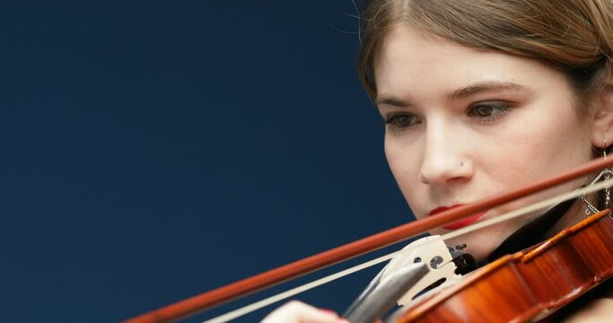 Young violinist, blonde, fuchsia hair, red nails, dress