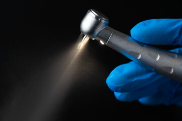Dentist hand with drill illustrates operation of dentist dental drill machine with water. Dentist's...