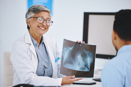 Happy, showing x ray and doctor with a man for medical advice, help and conversation. Radiology, healthcare and a mature woman holding a picture to show a patient results, research and hospital scan