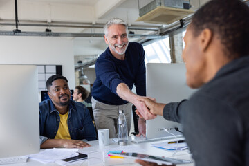 New employee being welcomed to the office with a handshake