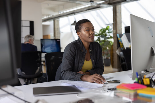 Young African American businesswoman working at a desktop computer in an office