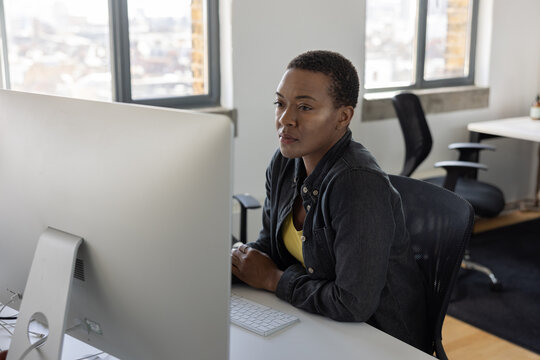 Young African American businesswoman working at a desktop computer in an office