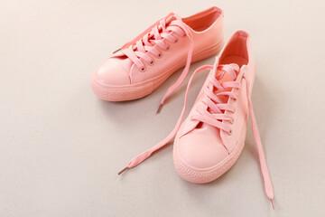 A pair of pink sneakers (trainers) on grey background.