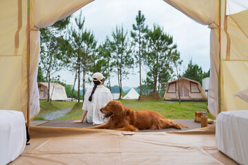 Golden Retriever accompanied by the owner lying in front of the tent door
