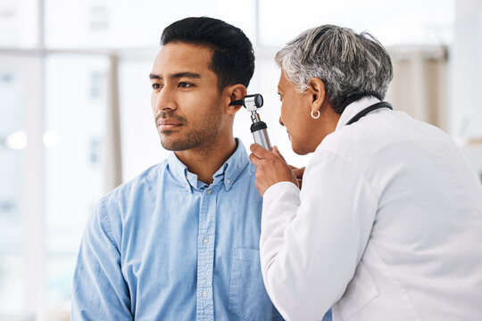 Doctor check patient ear, consultation and healthcare, people at hospital with otolaryngology specialist. Man and senior physician woman with otoscope test for hearing problem and health insurance