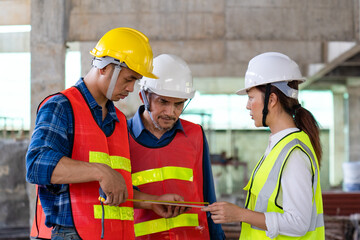 team of engineer, architect foreman together with safety operator measuring material while inspecting infrastructure construction progress for sustainable green building at site preparation