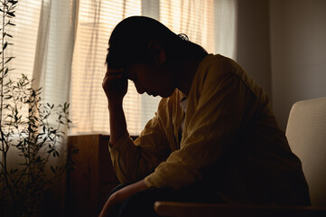 Silhouette photo of young Asian woman feeling upset, sad, unhappy or disappoint crying lonely in...