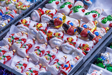 Fototapeta na wymiar European Christmas market stall in Old Town. colorful Christmas ornaments are some of the most popular souvenirs with tourists at seasonal fairs.