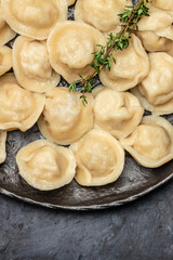 Traditional pelmeni, ravioli, dumplings with meat on a dark background. banner, menu, recipe place for text, top view.