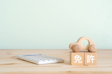免許と書かれたブロックと車のおもちゃと電卓