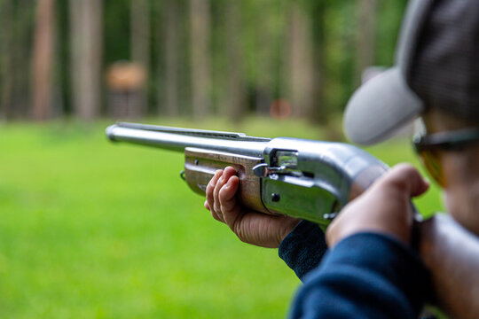 Skeet Shooting .Man shooting at target on an outdoor shooting range at sunny day, training alone, confident and skilled, experienced. Shooting and Guns.