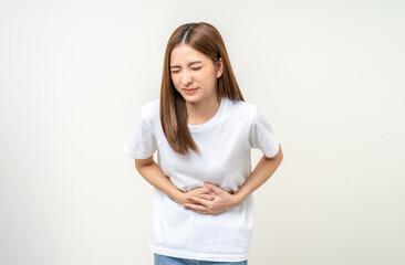 Fototapeta premium A woman had a stomach ache and gastritis. She put her hand on her stomach and squeezed it to relax and soothe. She is 25 years old and has menstrual cramps. Shot on isolated white background.