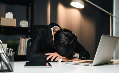 The business man worked so hard that he fell asleep at his desk. Working overtime because it's almost time for the deadline. He was tired from job and took a nap.