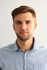 Fototapeta premium Portrait of handsome young man in blue shirt. Serious smart successful leader man
