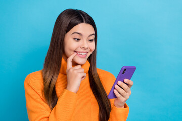 Photo of pleasant cheerful girl wear knit turtleneck directing look at phone read email finger on lips isolated on blue color background