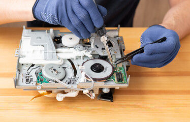 a man repairs and solders microcircuits for household appliances