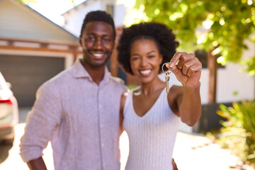 Portrait Of Couple Outdoors Holding Keys To Dream Home