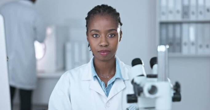 Black woman, scientist with serious face and science study in laboratory, microscope and medical research. Portrait, happy female doctor with experiment and scientific innovation in biotechnology