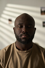 Obraz premium Vertical image of African American man with closed eyes concentrating his attention